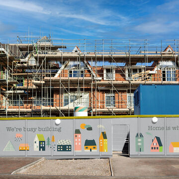 Entrance,To,Building,Site,With,Blue,Wooden,Fence,Against,Blue